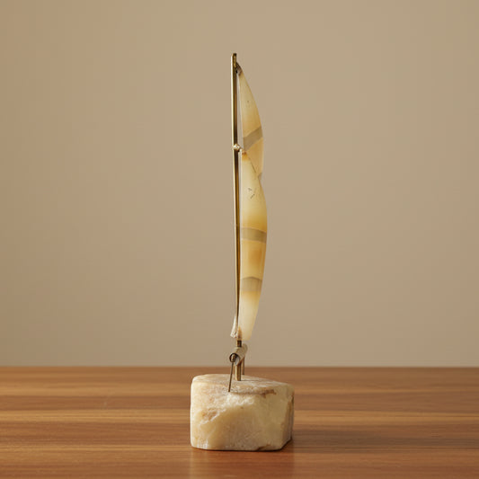 Profile of Mid Century Brass and Copper Metal Sailboat on Quartz shitting on shelf.