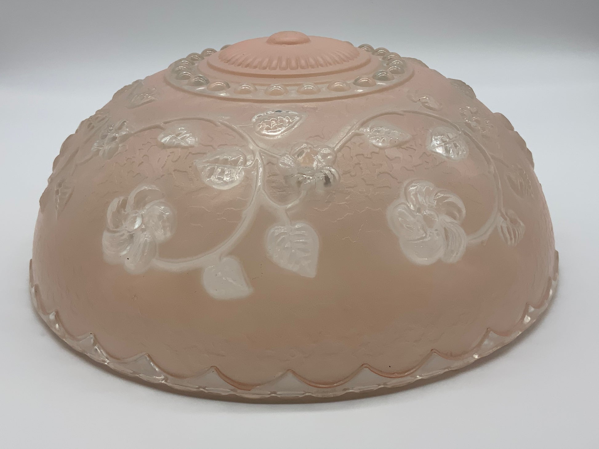 1945-1950's Post War Era  Clear and Blush Pink Pressed Glass Ceiling Light Shade Features a center circular nipple style design adorned with a repeating flower and leaf pattern. Dusty pink is painted airbrushed on the outside and the embossed raised floral pattern is clear.  10.25 Diameter x 4" Deep  Three Glass Hole Mounts  No Chips or Cracks